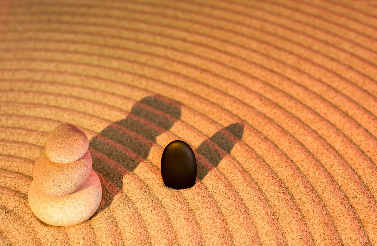 A hand-raked zen garden holds its pattern only because someone re-rakes it constantly, the same job a manual life OS quietly hands to you